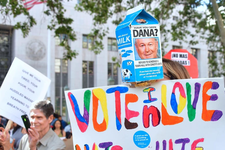 A protest sign reads "HAVE YOU SEEN DANA?" criticizing the Republican for refusing to meet with constituents.